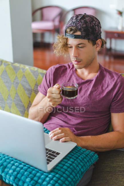 Hombre descansando y utilizando el ordenador portátil - foto de stock