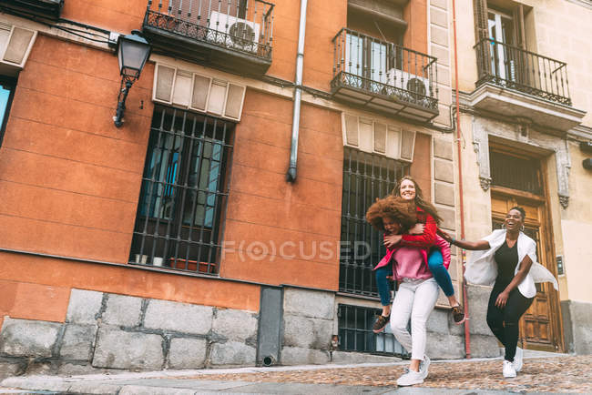 Femmes riantes marchant dans la ville — Photo de stock