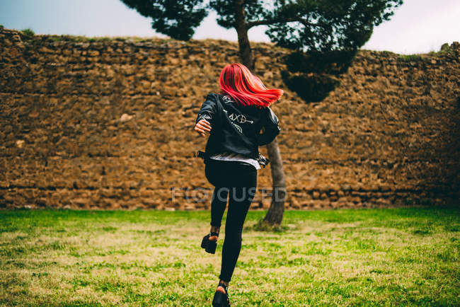 Stylish woman running on lawn — Stock Photo