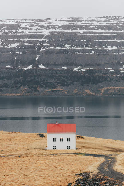 Remote house on terrain of lake coastline — Stock Photo