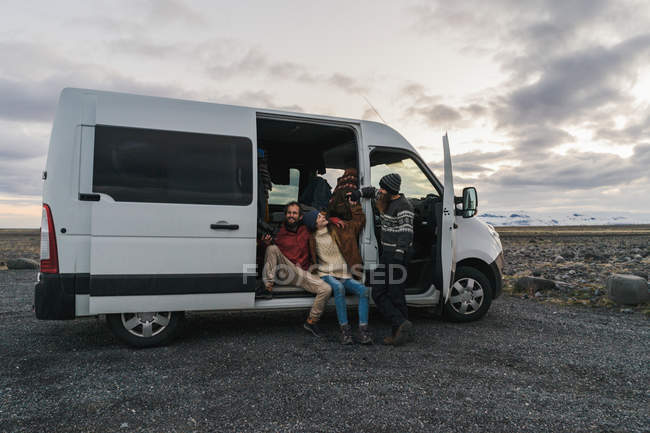 Travelers sitting in minibus with open door — Stock Photo