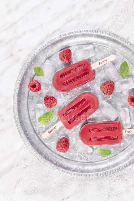 Top view of tasty fresh popsicles placed in the bowl with ice. — Stock Photo