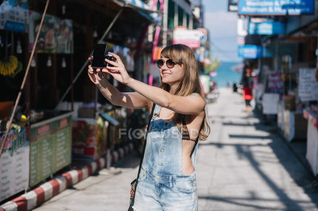 Woman taking selfie on street — Stock Photo