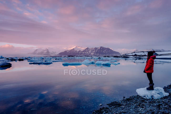Turista in piedi al lago ghiacciato — Foto stock