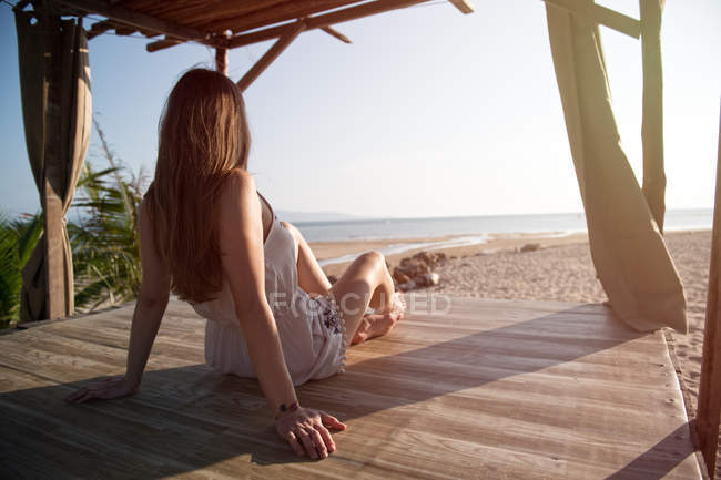 Donna seduta sulla spiaggia di sabbia — Foto stock