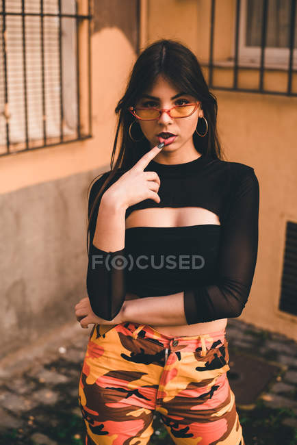 Donna che indossa occhiali da sole e pantaloni colorati — Foto stock