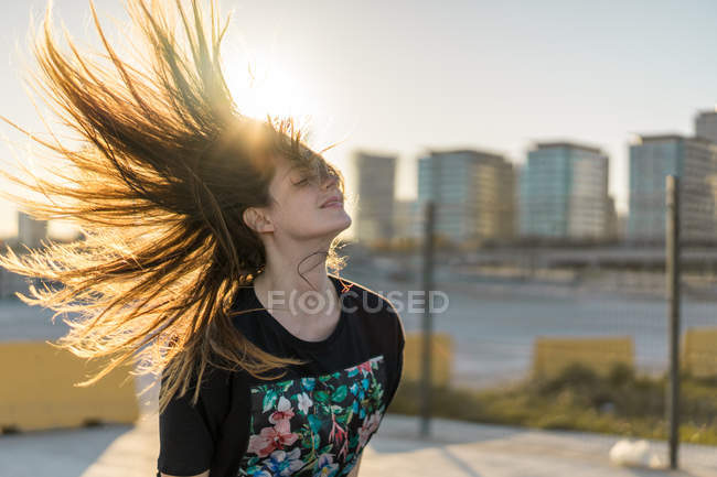 Woman standing in sunny town — Stock Photo