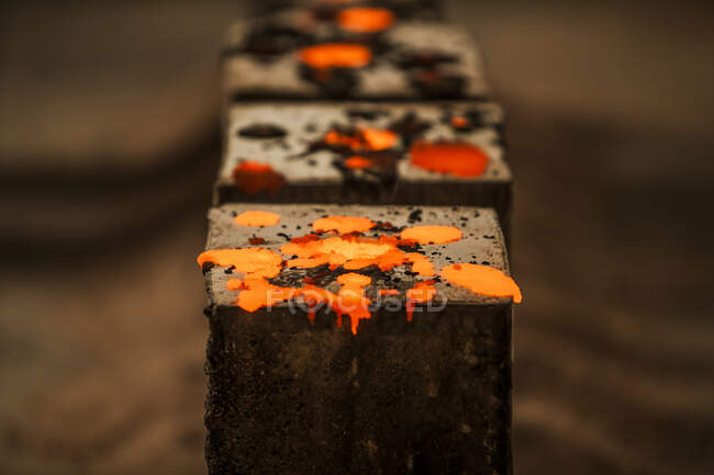Crop close-up view of drops warm iron in metal casting factory — Stock Photo