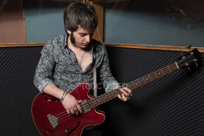 Homme jouant de la guitare en studio — Photo de stock