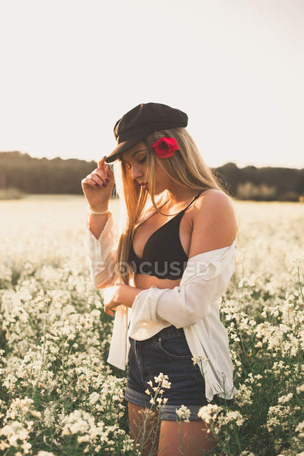 Donna in piedi in campo al tramonto — Foto stock