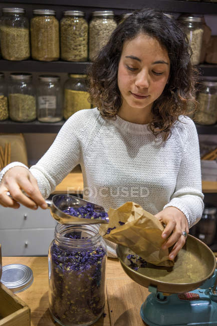 Woman putting spices to bag — Stock Photo