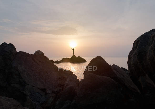 Woman standing on coastal rock — Stock Photo