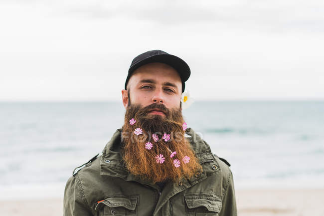 Homme avec des fleurs à la barbe — Photo de stock