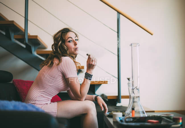 Женщина курит марихуану в стеклянном тупом виде — стоковое фото