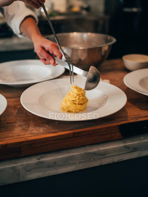Koch serviert Spaghetti — Stockfoto