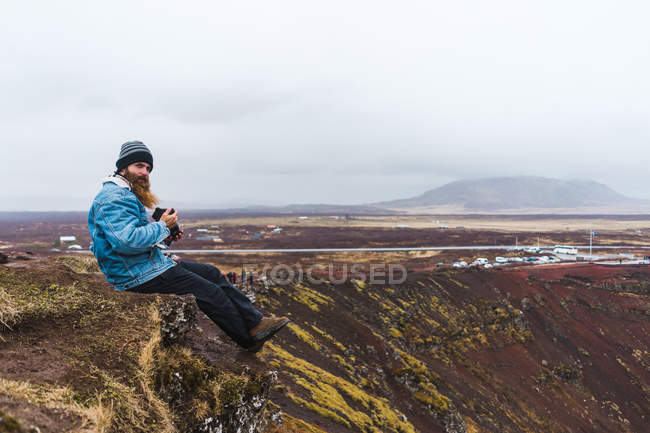 Homem sentado no poço aberto — Fotografia de Stock
