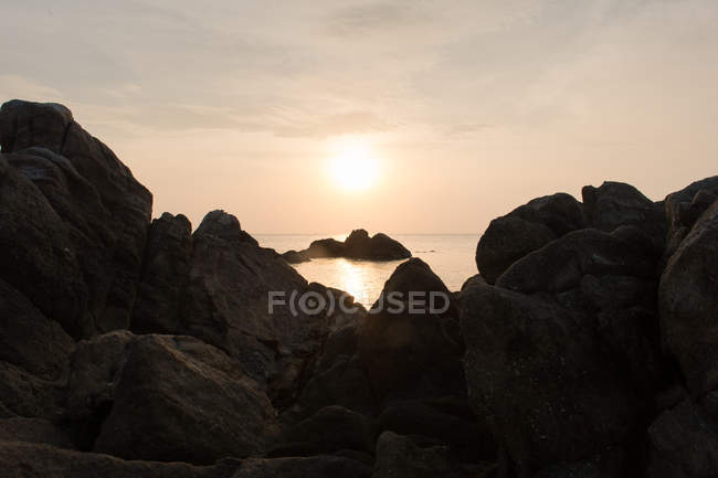 Puesta de sol sobre costa rocosa - foto de stock