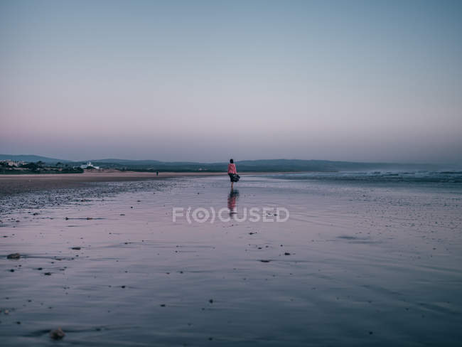 Mujer caminando en la playa de arena - foto de stock