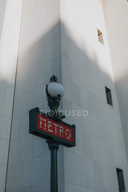 Red metro sign and lamp at modern building on street in Paris, France — Stock Photo