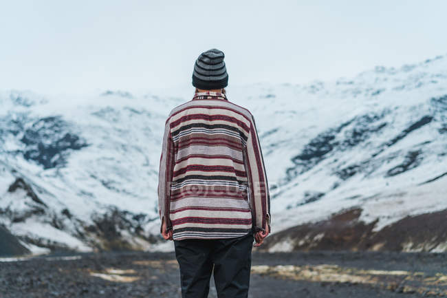 Homme debout dans les montagnes enneigées — Photo de stock