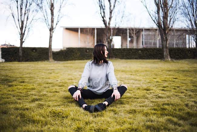 Женщина сидит на траве — стоковое фото