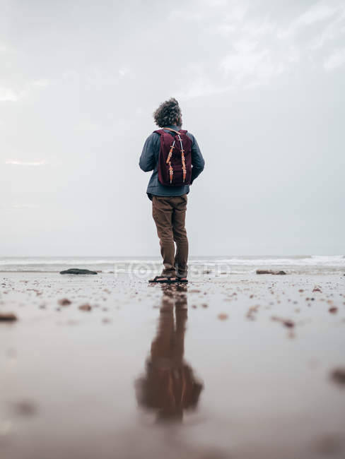 Uomo in piedi in mare calmo — Foto stock