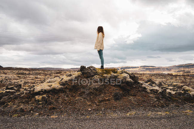 Donna in piedi sulla roccia — Foto stock
