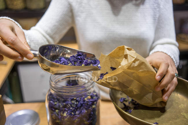 Woman putting spices to bag — Stock Photo