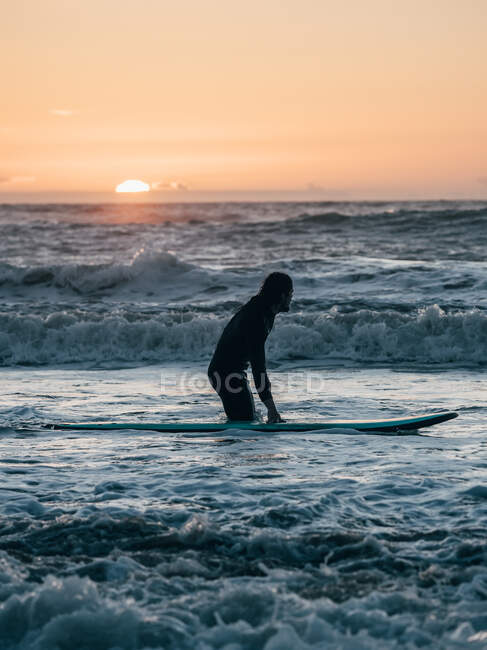 Surfista con tabla en la costa - foto de stock