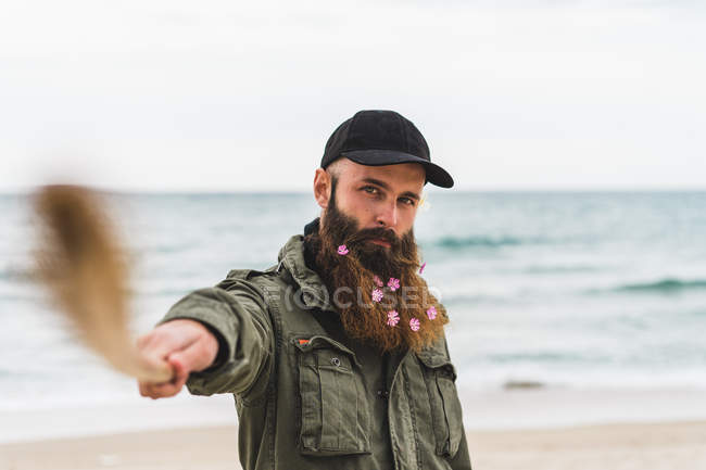 Hombre con palo y flores en barba - foto de stock