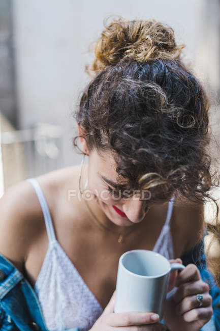 Laughing woman with cup of coffee on balcony — Stock Photo