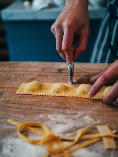 Hands cutting ravioli — Stock Photo