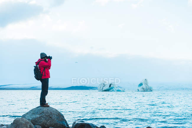 Homme prenant une photo du lac — Photo de stock