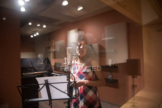 Female vocalist singing in studio — Stock Photo