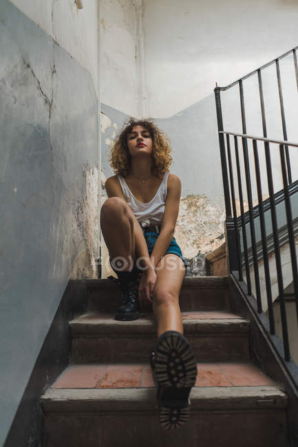 Femme assise sur des marches minables — Photo de stock