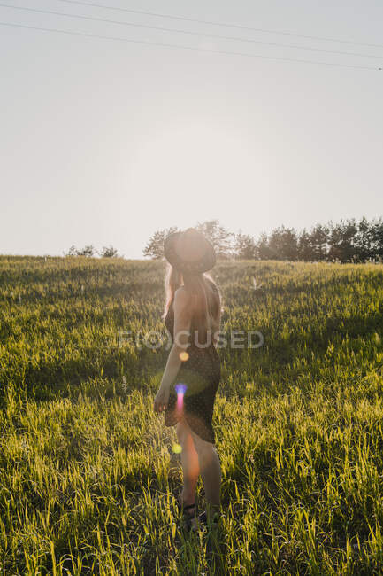 Donna con fiori in sole lucente — Foto stock