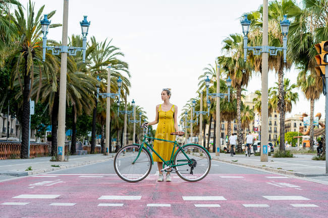 Frau steht mit Fahrrad — Stockfoto