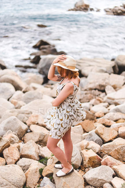 Mujer con sombrero de pie sobre rocas - foto de stock