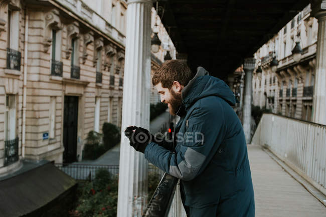 Чоловік використовує смартфон на старій вулиці міста — стокове фото