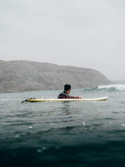 Surfista con tavola sulla costa — Foto stock