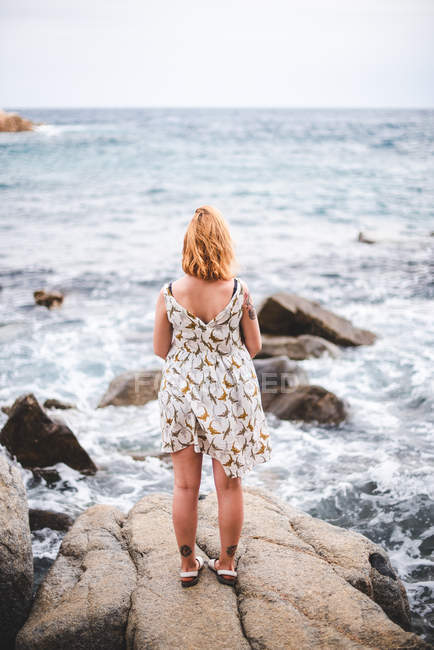Donna in piedi sulle rocce — Foto stock