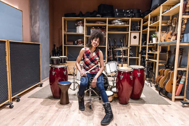 Женщина сидит рядом с барабанами — стоковое фото