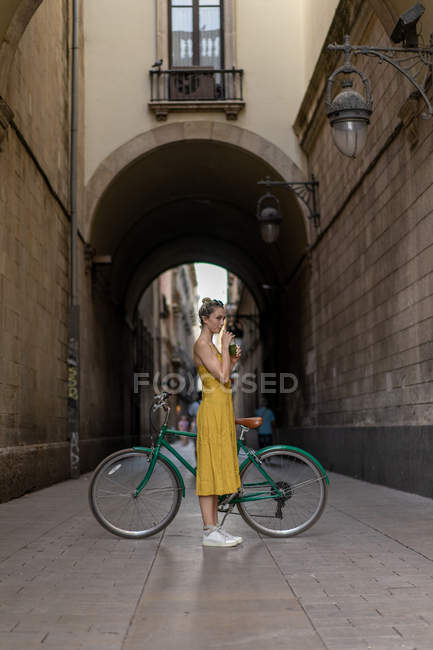 Mulher de pé com bicicleta vintage — Fotografia de Stock