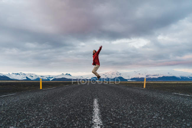Homem pulando na estrada pitoresca — Fotografia de Stock