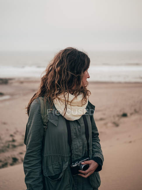 Жінка стоїть на узбережжі океану — стокове фото