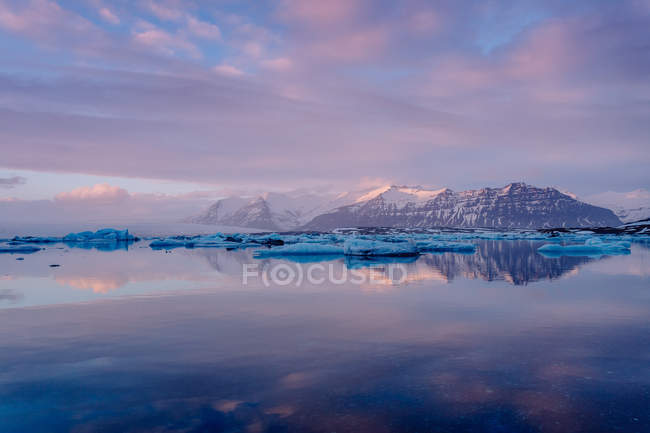 Lago ghiacciato e montagne al tramonto — Foto stock