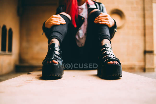 Trendfrau sitzt auf alter Empore — Stockfoto