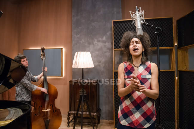 Woman singing on band rehearsal — Stock Photo