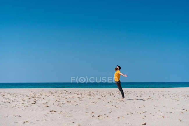 Человек, стоящий на песчаном пляже — стоковое фото