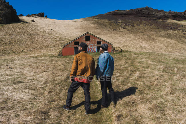 Homens em pé na frente de uma pequena casa — Fotografia de Stock